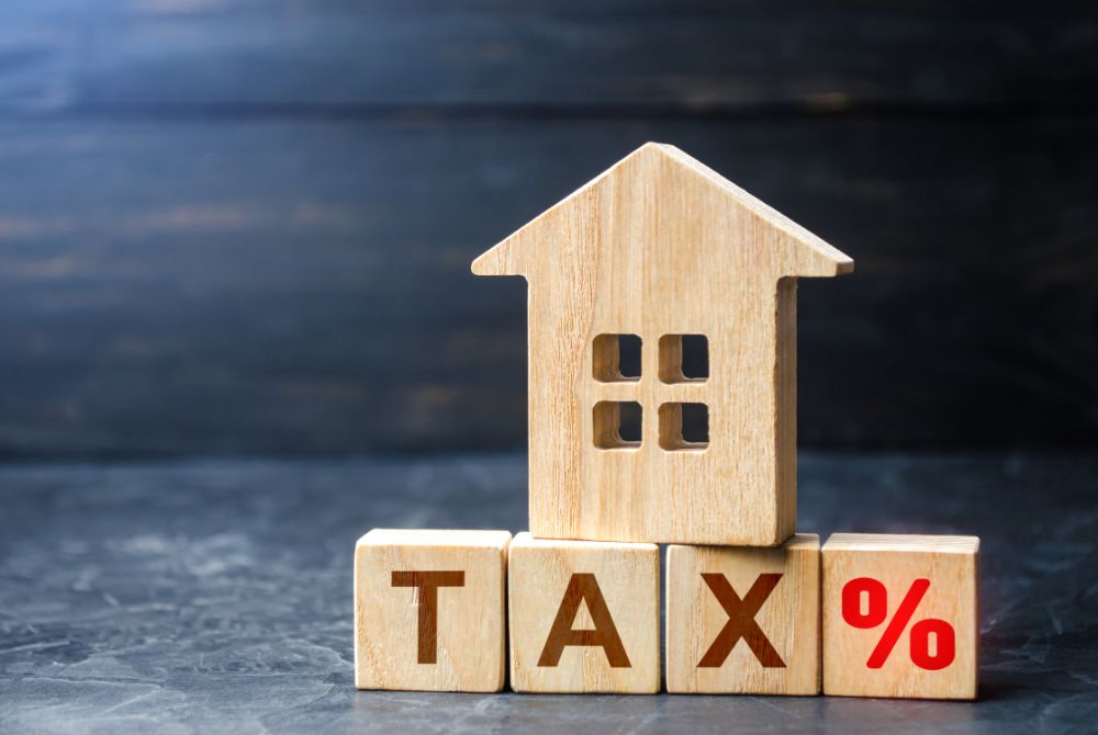 wooden blocks depicting a house and tax sign