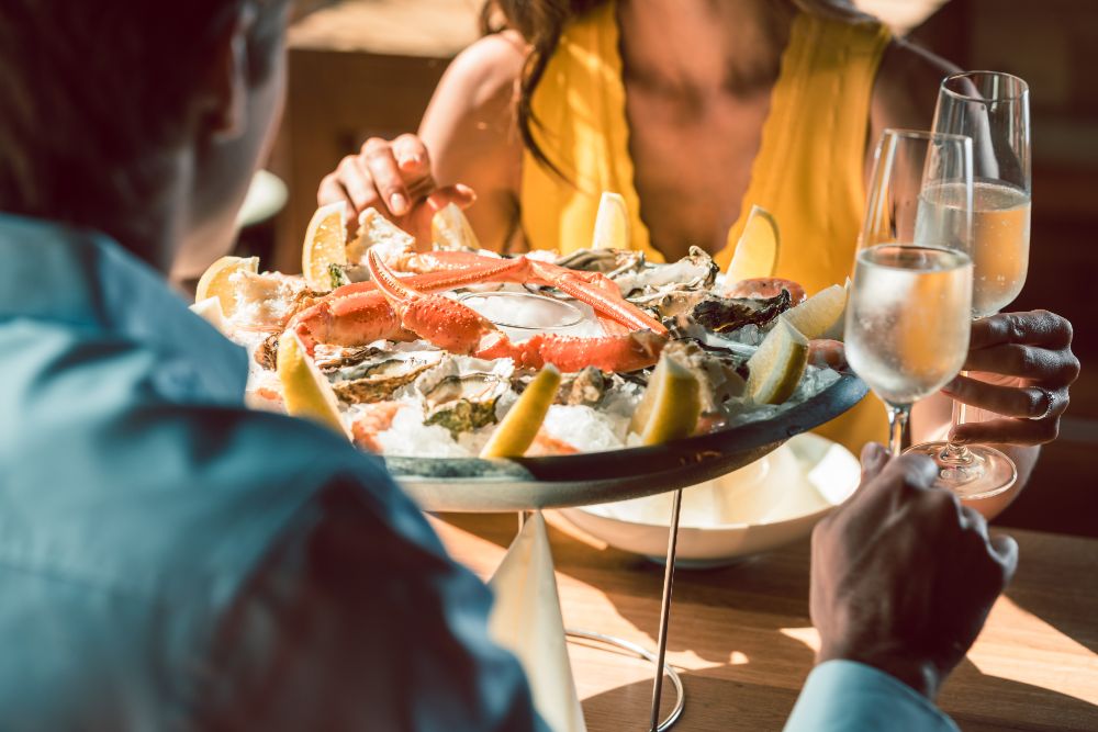 Couple eating oysters, crab and other seafood