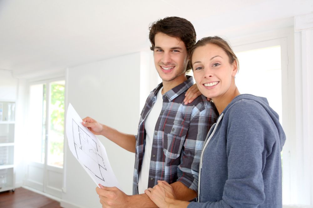 homebuyers holding house blueprint